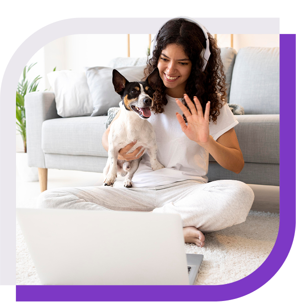 image of a woman holding a dog and smiling at a laptop