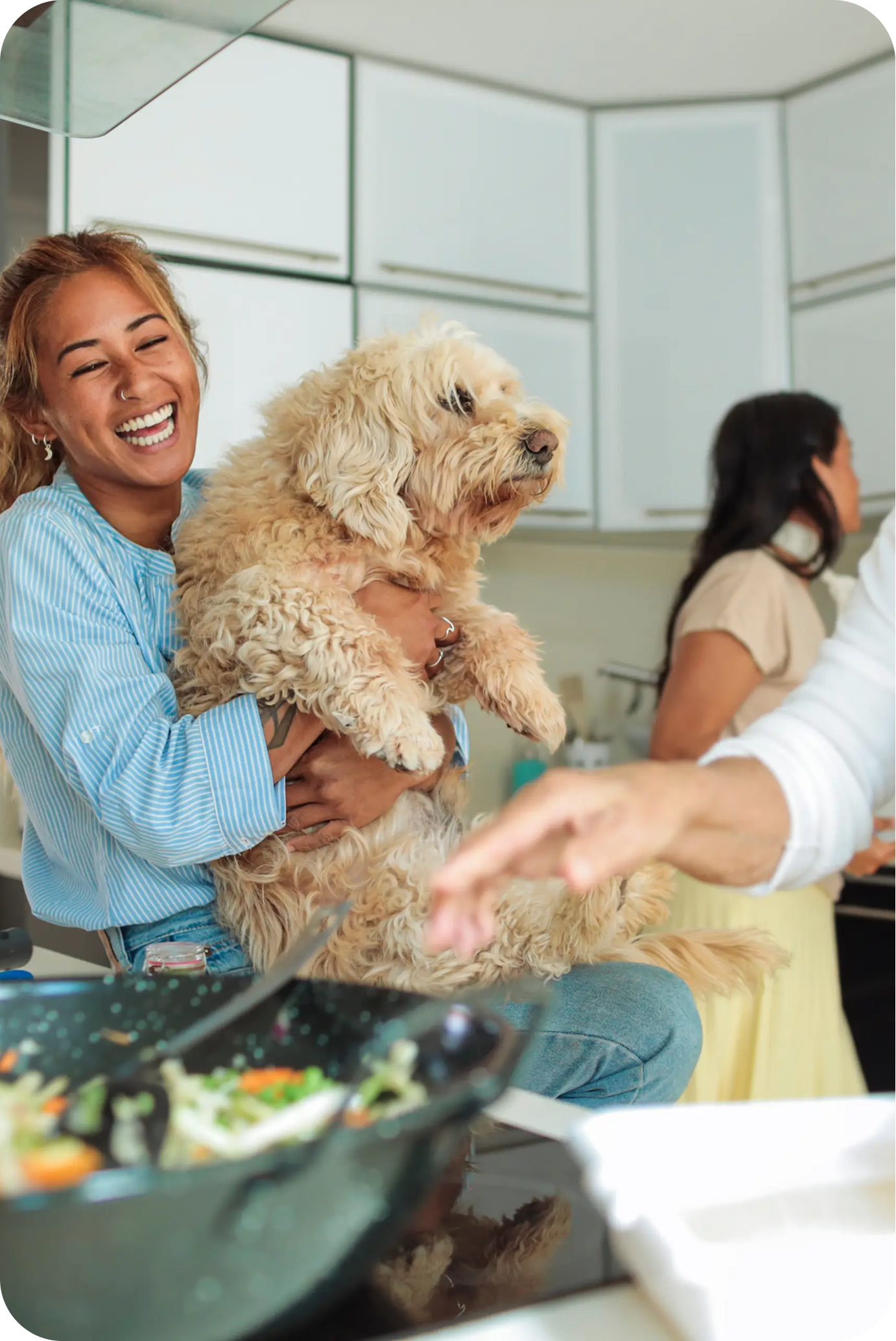 image of a happy family in the kitchen with their fluffy brown dog